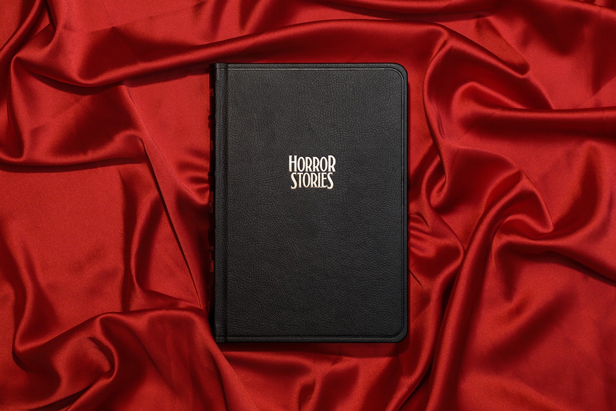 Photographie du numéro 71 Horror de McSweeney, présenté dans une couverture noire avec un texte blanc indiquant « histoires d'horreur », posée sur un tas de tissu en soie rouge.