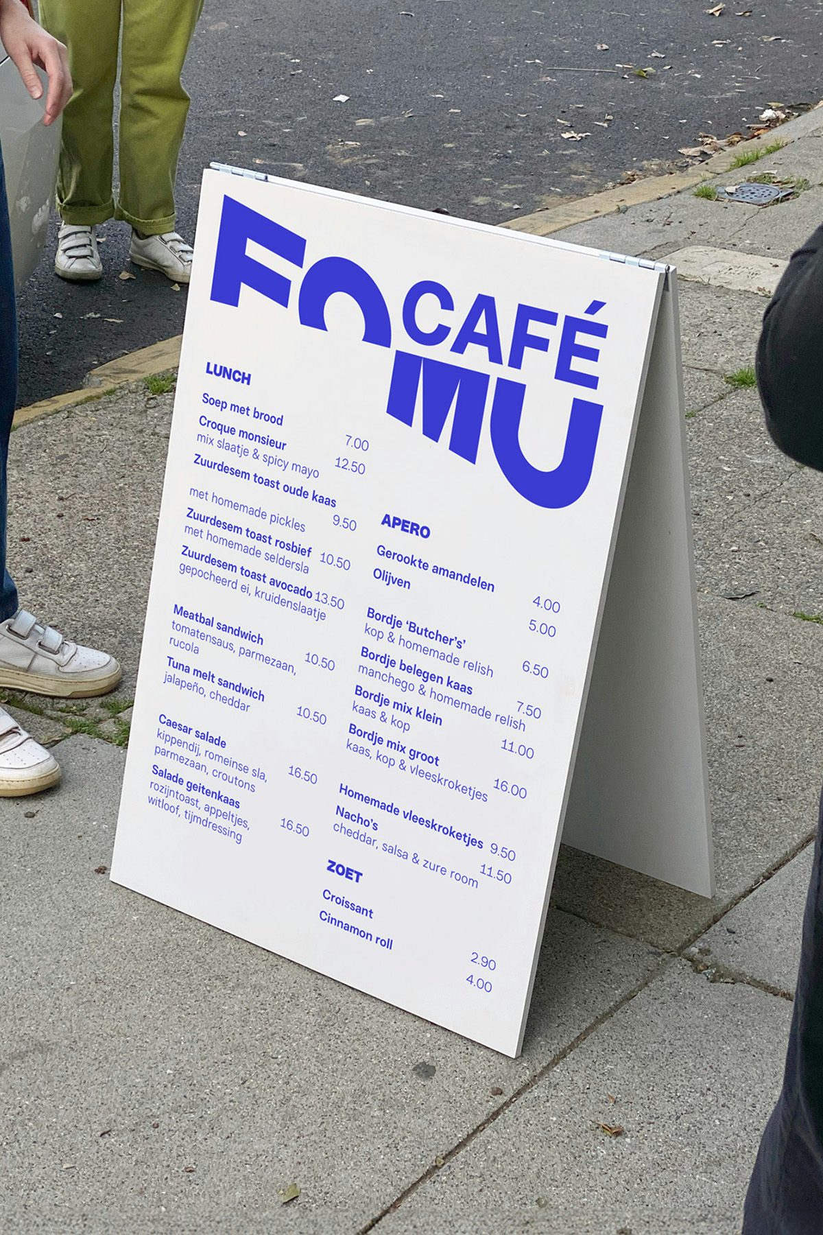 Menu du café Fomu avec le mot-symbole du musée tranché en diagonale rendu en bleu