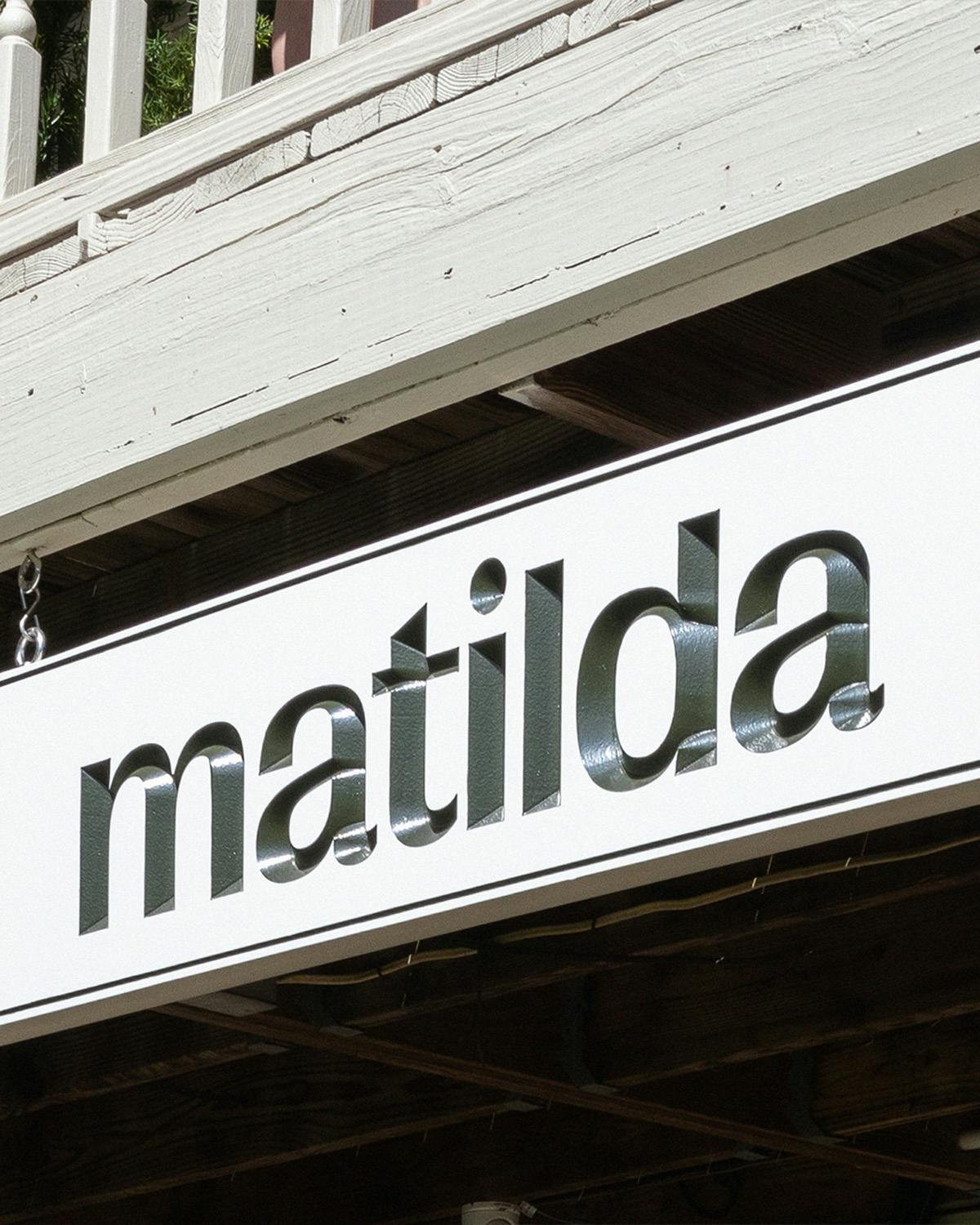 Panneau de restaurant sur lequel est écrit « Matilda » en lettres vertes en relief