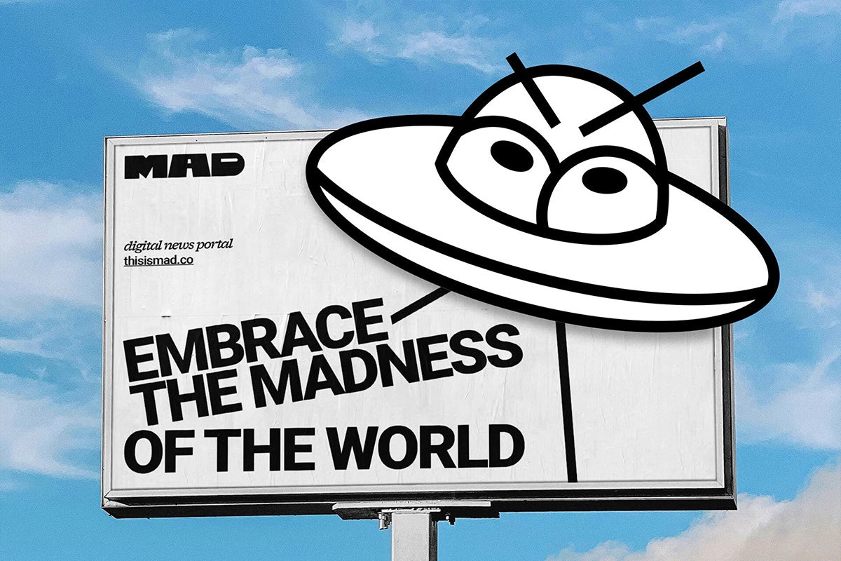 Panneau d'affichage extérieur avec le slogan « Embrassez la folie du monde » à côté d'une illustration en ligne d'un OVNI contenant des yeux de dessin animé fronçant les sourcils