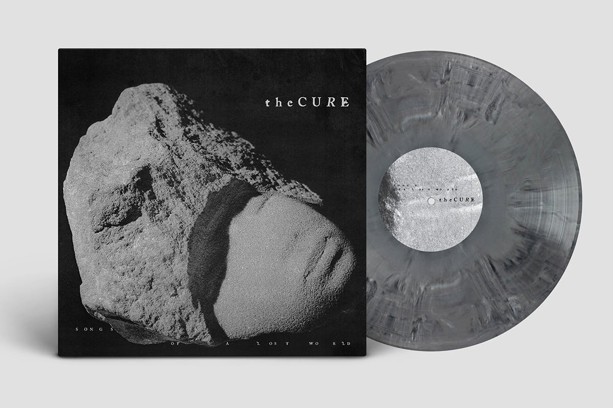 Pochette vinyle et disque de l'album Songs of a Lost World de The Cure présentant une statue de pierre en forme de visage